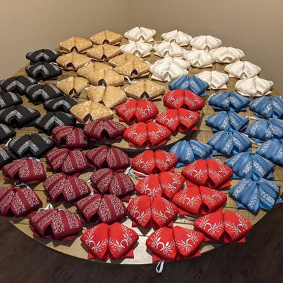 Collection of mariachi monos in assorted colors including black, gold, white, red, blue, and cream